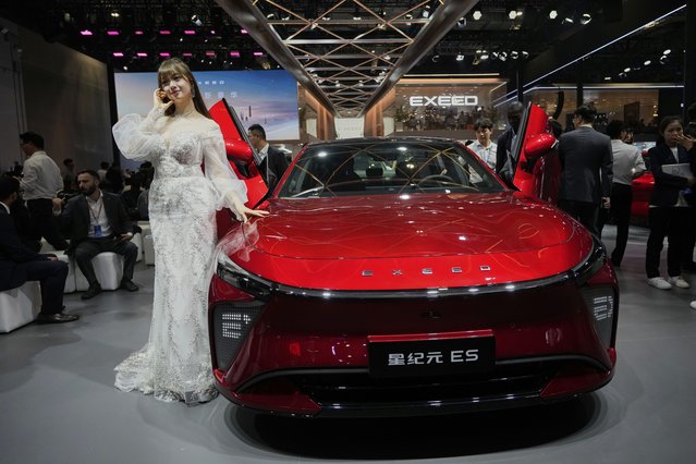 A model poses next to a car from Exeed at the Shanghai auto show on Wednesday, April 23, 2025. (Photo by Ng Han Guan/AP Photo)