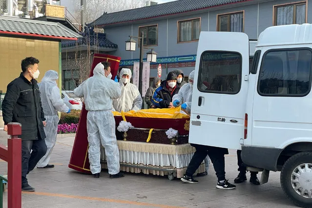 Workers in protective suits transfer a body in a casket at a funeral home, amid the coronavirus disease (COVID-19) outbreak in Beijing, China on December 17, 2022. (Photo by Alessandro Diviggiano/Reuters)