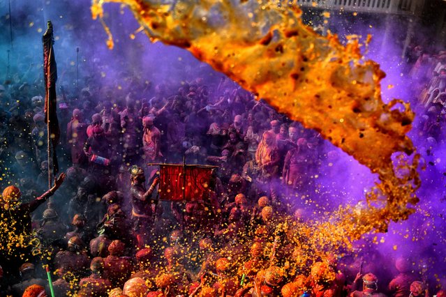 Hindu devotees play with water & colorful powders (Gulal) at the Radharani Temple of Nandgaon during the Holi festival on March 19, 2024. Holi Festival of India is one of the biggest colorful celebrations in India as many tourists and devotees gather to observe this colorful event, which marks the beginning of spring. The festival celebrates the divine love of Radha and Krishna and represents the victory of good over evil. (Photo by Avishek Das/SOPA Images/Rex Features/Shutterstock)
