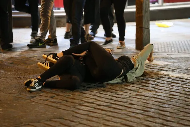 A pair have a hug in the Liverpool road as another person joins a girl who has taken a tipsy tumble in Liverpool, United Kingdom on September 21, 2016. (Photo by Paul Jacobs/FameFlynet UK)