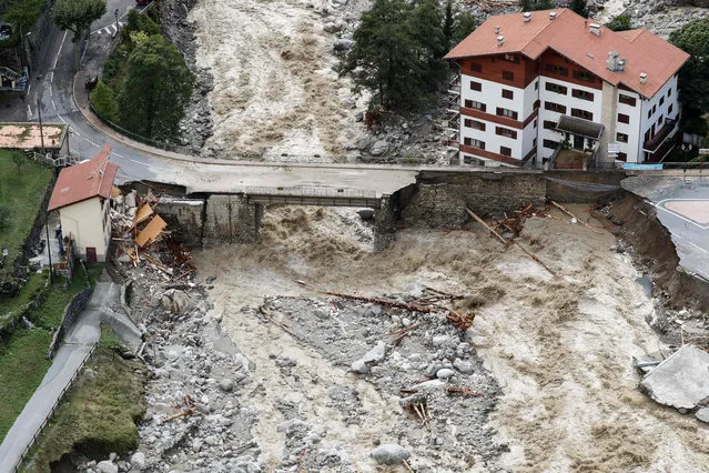 This aerial view taken on October 3, 2020 shows flood waters surging through Saint-Martin-Vesubie, southeastern France, after heavy rains and floodings hit the Alpes-Maritimes department. Heavy rains and brutal floods have left villages cut off from the world in the Alpes Maritimes, where hundreds of fire-fighters have been mobilised on October 3, to find nine missing persons. (Photo by Valery Hache/AFP Photo)