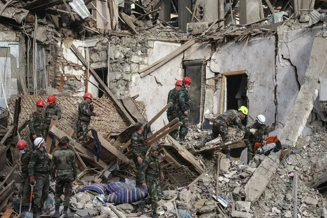 Search and rescue operations continue among debris of houses after Armenian army's alleged attacks with long-range missiles, on October 11, 2020 in Ganja city of Azerbaijan. The Armenian army continues to target civilian settlements, far from Azerbaijan's front line. It is reported that at least 5 people were killed and 28 others were injured in Ganja. (Photo by Onur Coban/Anadolu Agency via Getty Images)