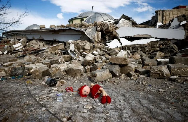 A doll lies on the ground near the site of a collapsed mosque, following an earthquake in Hatay, Turkey on February 7, 2023. (Photo by Guglielmo Mangiapane/Reuters)