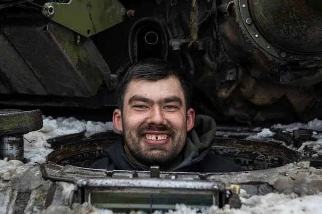 A Ukrainian serviceman smiles as he sits inside a tank outside the frontline town of Bakhmut, amid Russia's attack on Ukraine, in Donetsk region, Ukraine on February 14, 2023. (Photo by Yevhenii Zavhorodnii/Reuters)