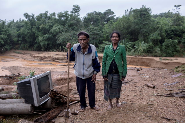 Ho Van Kang stands with his wife Ho Thi Nhe on ruins of their former house which was damaged by a landslide in Quang Tri province, Vietnam on October 21, 2020. (Photo by Thanh Dat/VNA via Reuters)