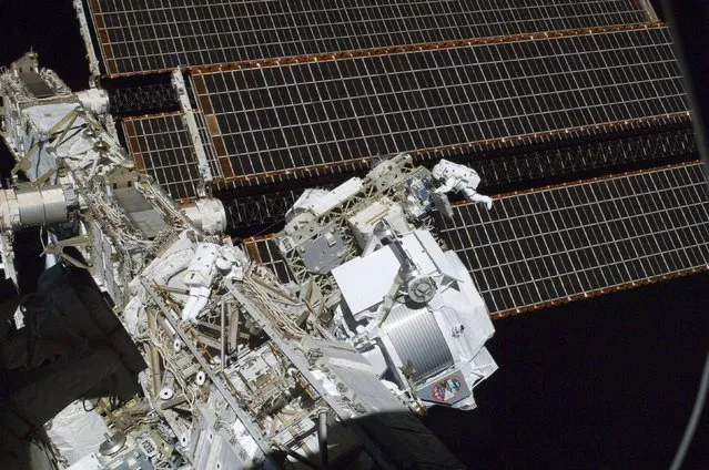Dwarfed by the International Space Station NASA astronauts Andrew Feustel (R) and Greg Chamitoff (L)work during their first spacewalk of the STS-134 mission in support of construction and maintenance, on May 20, 2011, in this NASA handout image. (Photo by Reuters/NASA)