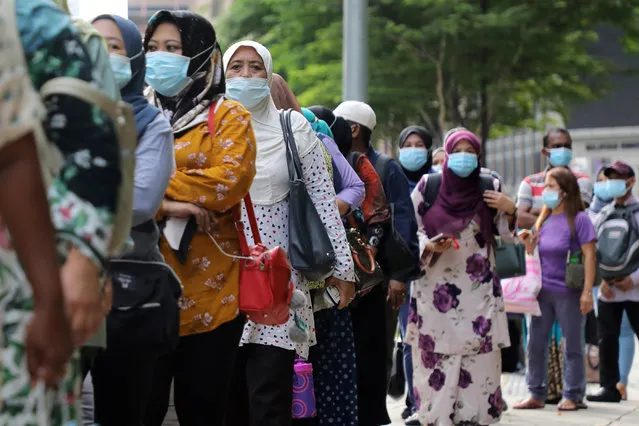Passengers wearing protective masks wait in line to board a bus at a bus station, amid the coronavirus disease (COVID-19) outbreak in Kuala Lumpur, Malaysia on October 2, 2020. (Photo by Lim Huey Teng/Reuters)