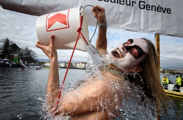 A swimmer disguised as a hard rock musician pours cold water on himself prior to dive into Lake Geneva during the 79th “Coupe de Noel” (Christmas Cup) swimming race, on December 17, 2017 in Geneva. More than 2000 participants took part in the event, a 120-meter-long swimming off the Geneva's bank in the 6.1 degrees Celsius cold water. (Photo by Fabrice Coffrini/AFP Photo)