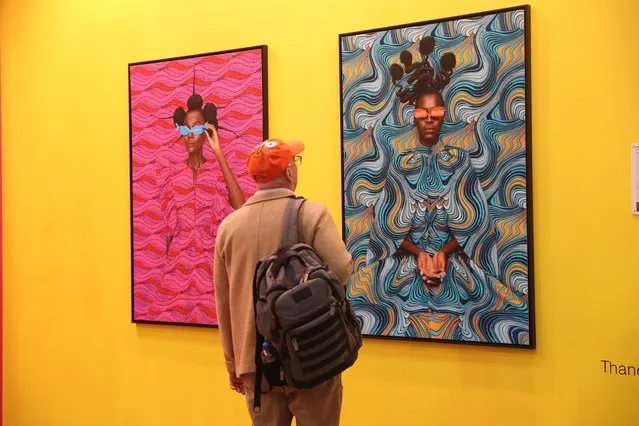 A man looks at photographs by Kenyan artist Thandiwe Muriu during the first day of the Zona Maco art fair in Mexico City, Mexico, 08 February 2023. The Zona Maco Mexican art fair, one of the most important in Latin America, kicked off this 08 February bringing together more than 200 gallery owners, artists and representatives of national and international museums. (Photo by Sashenka Gutierrez/EPA/EFE)