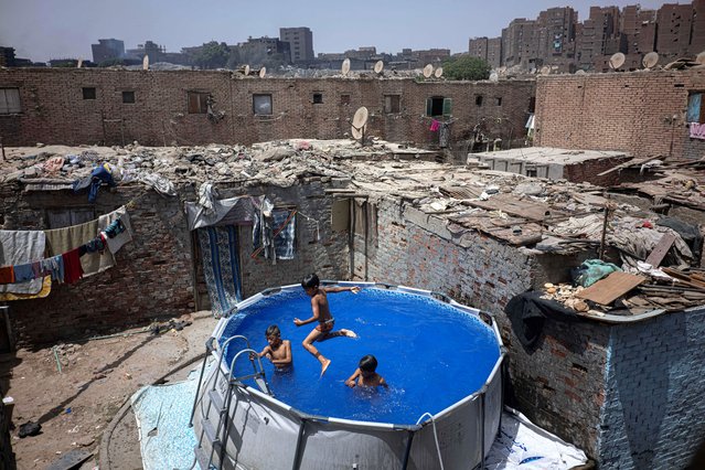 Boys cool down in a portable swimming pool in al-Duwaiqa neighborhood of Cairo on July 29, 2025. (Photo by Khaled Desouki/AFP Photo)