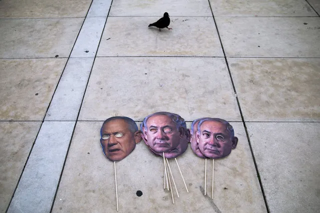 Masks depicting Israeli Prime Minister Benjamin Netanyahu and Israeli Defense Minister Benny Gantz lay on the ground during a protest against a parliamentary vote to dissolve the Knesset and send the country to its fourth elections in two years while it still hasn't approved a national budget for 2020, in Tel Aviv, Wednesday, December 2, 2020. (Photo by Oded Balilty/AP Photo)