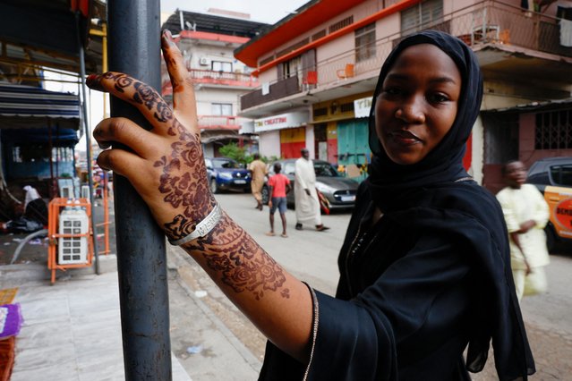 A Muslim girl with a henna tattoo on her arm waits to attend the prayer marking the Eid al-Adha festival, at the Grand Mosque of the Avenue 8 in Treichville, a district of Abidjan, Ivory Coast on June 16, 2024. (Photo by Luc Gnago/Reuters)