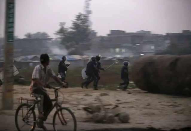 Nepalese police personnel chase Madhesi protesters (unseen) demonstrating against the new constitution in Birgunj, Nepal November 5, 2015. (Photo by Navesh Chitrakar/Reuters)