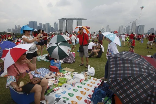 People enjoy a picnic on the Marina Barrage, which houses the pump house of the urban Marina Bay reservoir, Singapore, August 7, 2015. (Photo by Edgar Su/Reuters)