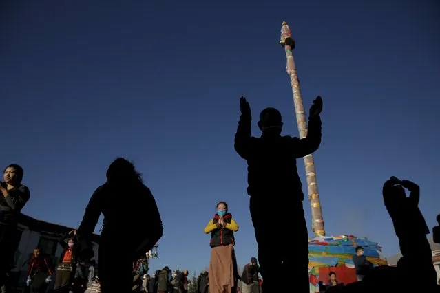 Pilgrims pray at the Jokhang Temple in central Lhasa, Tibet Autonomous Region, China as sun rises November 20, 2015. (Photo by Damir Sagolj/Reuters)