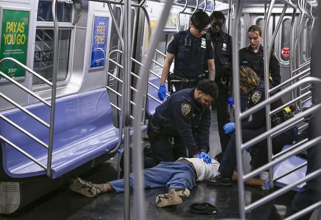 New York police officers administer CPR to a man at the scene where a fight was reported on a subway train, Monday, May 1, 2023, in New York. A man suffering an apparent mental health episode aboard a New York City subway died on Monday after being placed in a headlock by a fellow rider, according to police officials and video of the encounter. Jordan Neely, 30, was shouting and pacing aboard an F train in Manhattan, witnesses and police said, when he was taken to the floor by another passenger. (Photo by Paul Martinka via AP Photo)