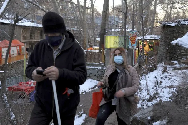People wearing protective masks hike at the Darakeh mountainous area, north of the capital Tehran, Iran, Friday, December 25, 2020. (Photo by Ebrahim Noroozi/AP Photo)