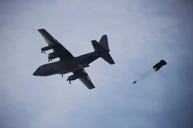 A Greek paratrooper jumps from a Hellenic Air Force C-130H Hercules plane during a show marking the Hellenic Air Force's Patron Saint celebration, on the southern suburb of Faliro, in Athens, Greece, November 6, 2016. (Photo by Alkis Konstantinidis/Reuters)