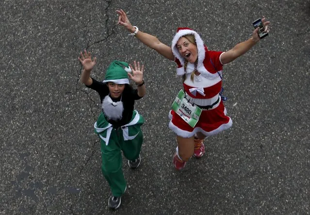 A woman in a Santarina outfit and a child react for the camera at the annual Carrera de Papa Noel (Santa Claus Run), in Madrid, Spain, December 12, 2015. (Photo by Javier Barbancho/Reuters)