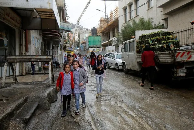 Palestinian school girls walk to their homes on a rainy day in Balata refugee camp near the West Bank city of Nablus November 1, 2016. (Photo by Abed Omar Qusini/Reuters)