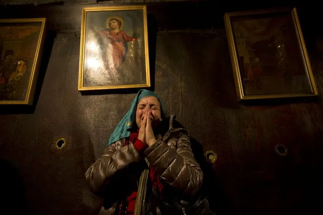 Christian pilgrims pray inside the Grotto of the Church of Nativity, traditionally believed by Christians to be the birthplace of Jesus Christ, in the West Bank town of Bethlehem on Christmas Eve, Thursday, December 24, 2015. (Photo by Majdi Mohammed/AP Photo)