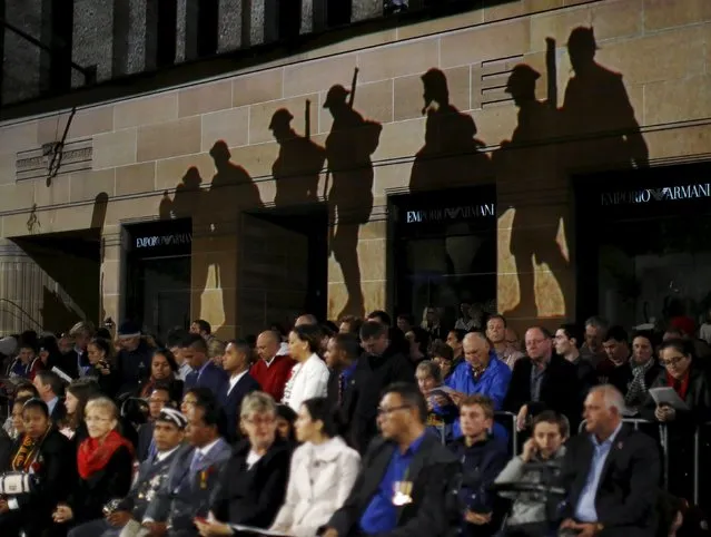 Silhouettes of ANZAC (Australian and New Zealand Army Corps) troops are projected onto the wall of a building above the crowd during the dawn of ANZAC Day 100th anniversary commemoration at Sydney's Cenotaph in Australia, April 25, 2015. (Photo by Jason Reed/Reuters)