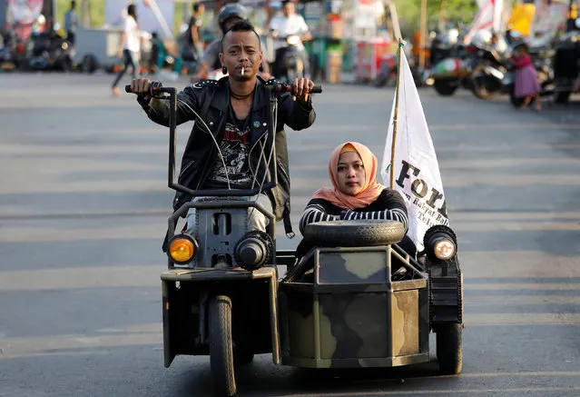 Extreme Vespa enthusiasts drive near the site of a scooter festival in Kediri, East Java, Indonesia, August 4, 2018. (Photo by Darren Whiteside/Reuters)