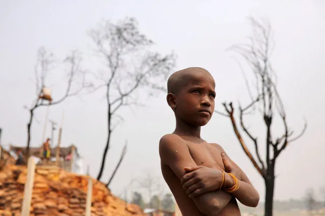 A Rohingya refugee boy looks on in a refugee camp where a massive fire broke out two days ago, Cox's Bazar, Bangladesh, March 24, 2021. (Photo by Mohammad Ponir Hossain/Reuters)
