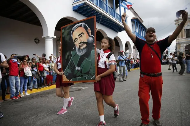 Students carry a portrait of Cuba's late President Fidel Castro as the caravan carrying Castro's ashes arrives in Santiago de Cuba, Cuba, December 3, 2016. (Photo by Carlos Garcia Rawlins/Reuters)
