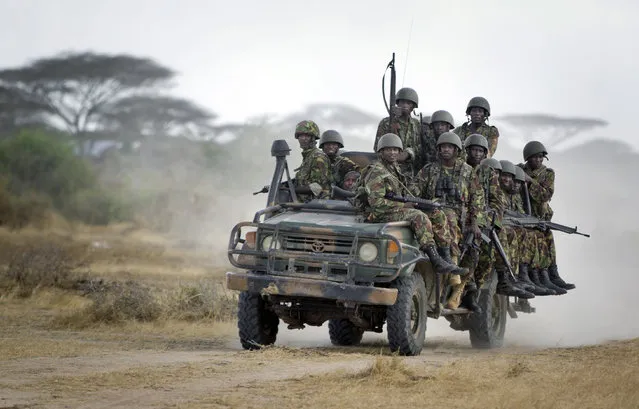 In this Monday, February 20, 2012 file photo, Kenyan army soldiers ride on a vehicle at their base in Tabda, inside Somalia. Heavily armed fighters from the Islamic extremist group al-Shabab attacked a base for African Union peacekeepers in southwestern Somalia on Friday, January 15, 2016, blasting their way into the compound and exchanging fire with peacekeepers, a Somali military official said. (Photo by Ben Curtis/AP Photo)
