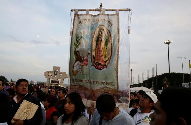 A pilgrim carries an image of the Virgin of Guadalupe as he arrives at the Basilica of Guadalupe during the annual pilgrimage in honor of the Virgin of Gudalupe, patron saint of Mexican Catholics, in Mexico City, Mexico December 11, 2016. (Photo by Henry Romero/Reuters)