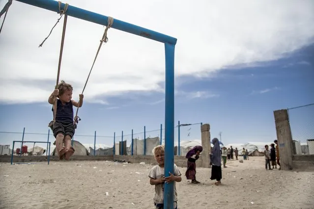 Children play at al-Hol camp that houses some 60,000 refugees, including families and supporters of the Islamic State group, many of them foreign nationals, in Hasakeh province, Syria, Saturday, May 1, 2021. Kurdish officials say security has improved at the sprawling camp in northeast Syria, but concerns are growing of a coronavirus outbreak in the facility. (Photo by Baderkhan Ahmad/AP Photo)