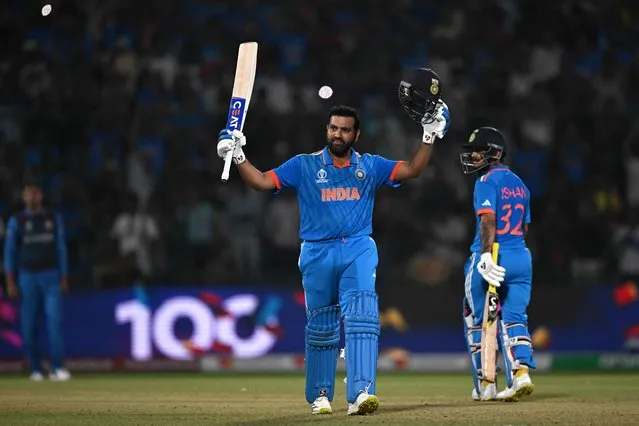 India's captain Rohit Sharma (C) celebrates after scoring a century (100 runs) as his teammate Ishan Kishan watches during the 2023 ICC Men's Cricket World Cup one-day international (ODI) match between India and Afghanistan at the Arun Jaitley Stadium in New Delhi on October 11, 2023. (Photo by Money Sharma/AFP Photo)