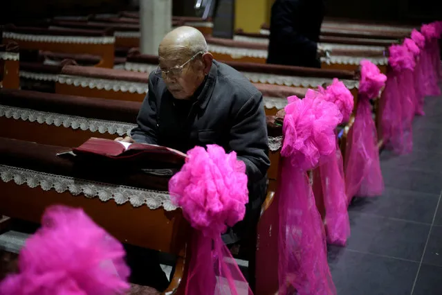 An elderly villager reads the Bible ahead of a Christmas eve mass at a Catholic church on the outskirts of Taiyuan, North China's Shanxi province, December 24, 2016. (Photo by Jason Lee/Reuters)