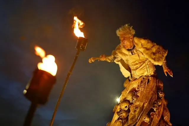 A member of street performance troupe Macnas performs while holding a sphere of light in his mouth during a Halloween parade called “Cnamha La Loba” in Galway, Ireland on October 29, 2023. (Photo by Clodagh Kilcoyne/Reuters)