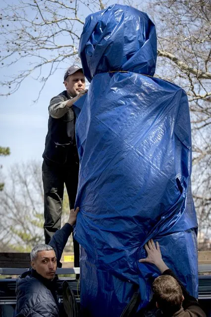 New York City Parks workers work to remove a large molded bust of Edward Snowden at Fort Greene Park in the Brooklyn borough of New York April 6, 2015. (Photo by Brendan McDermid/Reuters)
