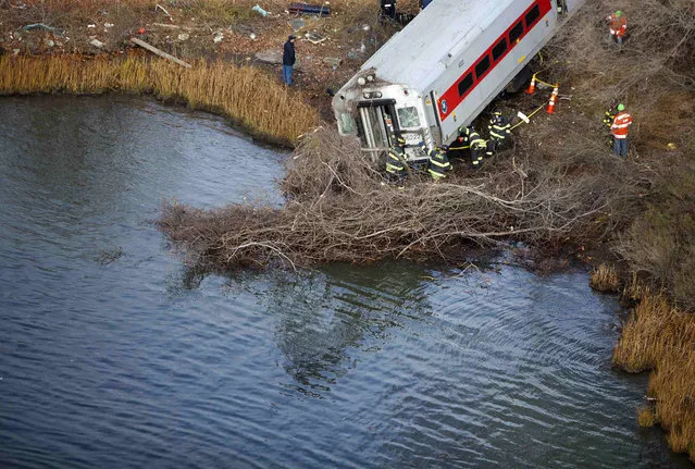 Emergency workers examine the site of a Metro-North train derailment in the Bronx borough of New York December 1, 2013. At least four people were killed and 63 injured, including 11 critically, when the suburban train derailed, with at least five cars from the Metro-North train sliding off the tracks, officials said. (Photo by Carlo Allegri/Reuters)