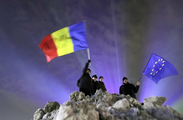 Romanian anti-government protesters demonstrate near the government headquarters, two days after the official launch of the Romanian Presidency of the Council of the European Union, in Bucharest, Romania, 12 January 2019. Tenths of demonstrators, waving placards, Romanian and EU flags, protested against announced pardon governance ordnance, as well against the newly implemented banking taxes. (Photo by Robert Ghement/EPA/EFE)