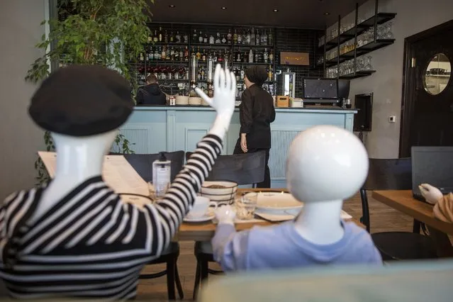 Mannequins are positioned at the tables of Bagolina eatery restaurant, as a protest against the latest government COVID-19 lockdown measures in Kosovo capital Pristina, Friday, April 9, 2021. Kosovar association of gastronomy have found an innovative way of protesting, sitting mannequins instead of customers in chairs of closed restaurants and cafeterias following the government's recent lockdown measures. (Photo by Visar Kryeziu/AP Photo)