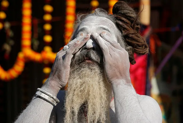 A Sadhu or a Hindu holy man applies ash on his face at a makeshift shelter before heading for an annual trip to Sagar Island for the one-day festival of “Makar Sankranti”, in Kolkata, India, January 7, 2019. (Photo by Rupak De Chowdhuri/Reuters)