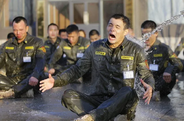 A trainee reacts as he is drenched with water during Tianjiao Special Guard/Security Consultant training on the outskirts of Beijing December 1, 2013. (Photo by Jason Lee/Reuters)