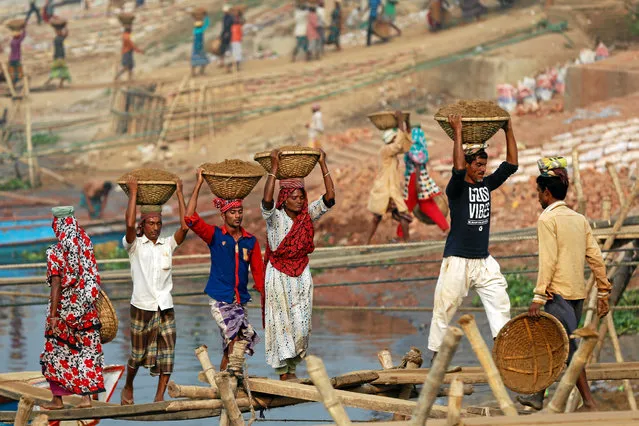 Bangladeshi workers unload sand from a ferry at the river Buriganga in Dhaka, Bangladesh December 20, 2016. (Photo by Mohammad Ponir Hossain/Reuters)