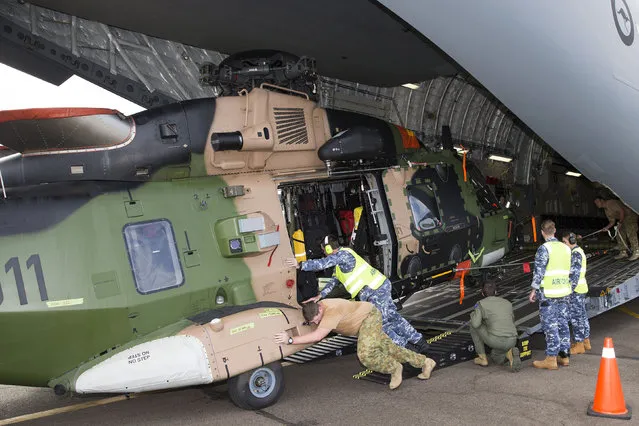 An Australian Army Taipan MRH-90 helicopter is unloaded from a Royal Australian Air Force C-17A aircraft in response to Cyclone Winston at Fiji's Nausori International Airport near Suva in this picture supplied by the Australian Defence Force, February 24, 2016. (Photo by Reuters/Australian Defence Force)