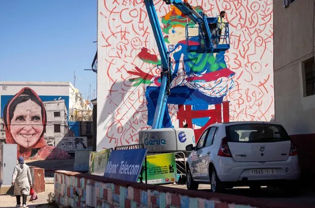 Moroccan street artist Omar Lhamzi works on a mural during the “Jidar” street art festival in the capital Rabat, on September 20, 2021. A wander through Rabat's avenues and alleyways reveals an array of freshly-painted works, in which larger-than-life fantasy creatures co-inhabit with realistic portraits and scenes of daily life. Their creators flocked from across the North African kingdom and beyond to Rabat last week for Jidar (Arabic for “wall”), a festival dedicated to street art. (Photo by Fadel Senna/AFP Photo)