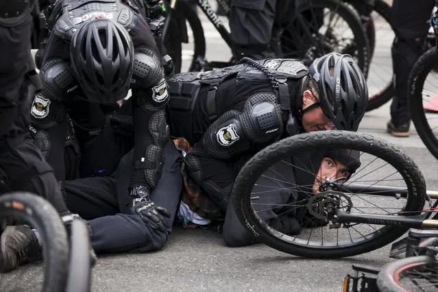 Police detain a demonstrator during an anti-capitalist protest in Seattle, Washington May 1, 2015. (Photo by David Ryder/Reuters)
