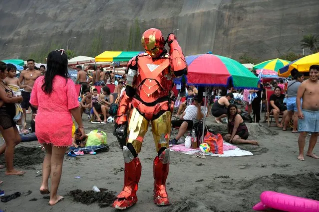 A performer wearing a Ironman costume takes a break at Agua Dulce beach in Lima, Peru, Sunday, January 29, 2023. Peru is amid political turmoil since former President Pedro Castillo was impeached and arrested for trying to dissolve Congress and was succeeded by his Vice-President Dina Boluarte, what sparked violent protest. (Photo by Martin Mejia/AP Photo)
