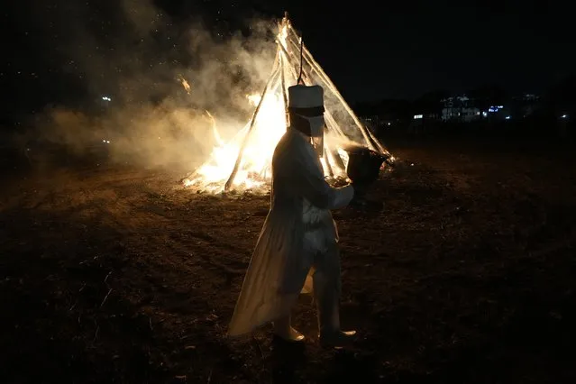 An Iranian Zoroastrian priest walks near a giant bonfire in a ceremony celebrating Zoroastrians ancient mid-winter Sadeh festival the outskirts of Tehran, Iran, Tuesday, January 30, 2024. (Photo by Vahid Salemi/AP Photo)