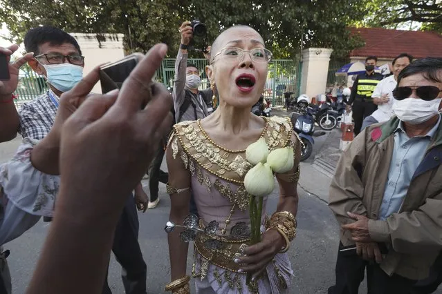Theary Seng, a Cambodian-American lawyer, dressed in a traditional Khmer Apsara dance costume, speaks to media as she arrives to continue her trial in the municipal court in Phnom Penh, Cambodia, Tuesday, December 7, 2021. Seng and over 40 other defendants charged with treason for taking part in nonviolent political activities were summoned back to court Tuesday to continue their trial that had been suspended since November 2020 due to the coronavirus. (Photo by Heng Sinith/AP Photo)