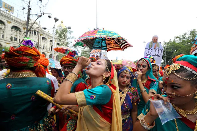 Bharatiya Janata Party (BJP) activists and dancers drink water as they walk a mass rally for BJP President Amit Shah in Kolkata, Eastern India, 14 May 2019. The parliamentary elections, which began on 11 April 2019, are to be conducted in seven phases throughout India and the result will be announced on 23 May. (Photo by Piyal Adhikary/EPA/EFE)