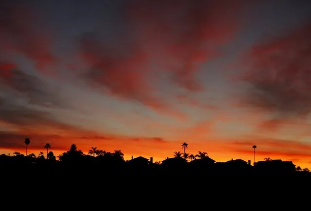 The morning sun rises behind residential homes on a hillside in Cardiff, California January 27, 2016. (Photo by Mike Blake/Reuters)